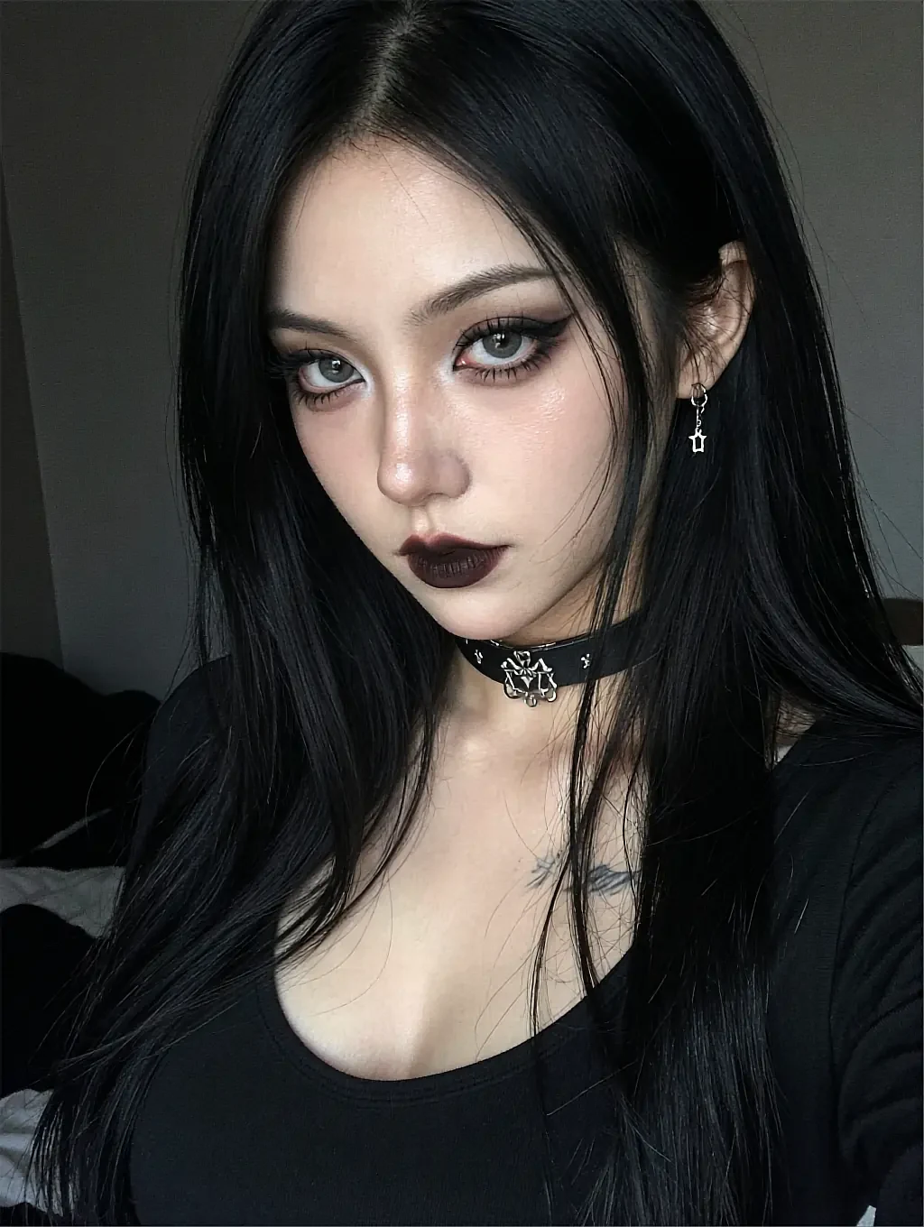 Fictional AI character with straight black hair, dark eye make-up and a ring choker